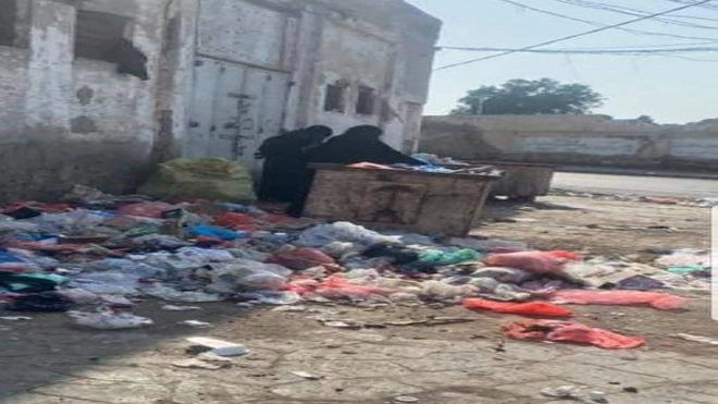يمنيتان في صنعاء تبحثان في القمامة عن بقايا طعام